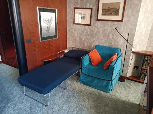 米兰MILAN SOUTH GATE APARTMENT的一间配备有蓝色沙发和椅子的客房