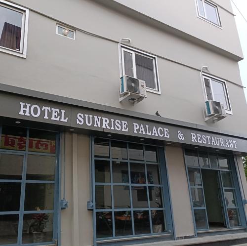 乌代浦Hotel Sunrise Palace的大楼上的日出宫殿和餐厅标志