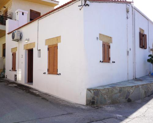 帕拉代西翁Alicia's Traditional Home In Paradisi的白色的建筑,在街上有棕色百叶窗