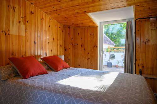 布鲁内特Amplio apartamento independiente con terraza的一间卧室配有一张带红色枕头的床和一扇窗户
