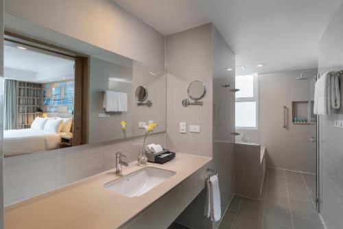 曼谷曼谷碧武里47莎玛服務式公寓的一间带水槽和镜子的浴室以及一张床