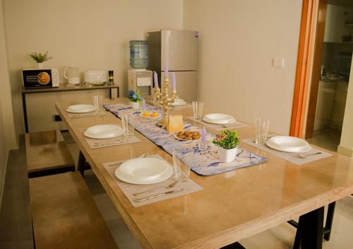 卡拉奇Hype Holiday Homes的一张长木桌子,上面有盘子和食物