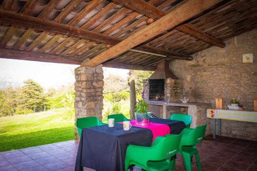 贝尔加Complex Rural Can Caubet的一间带桌子和绿色椅子的用餐室