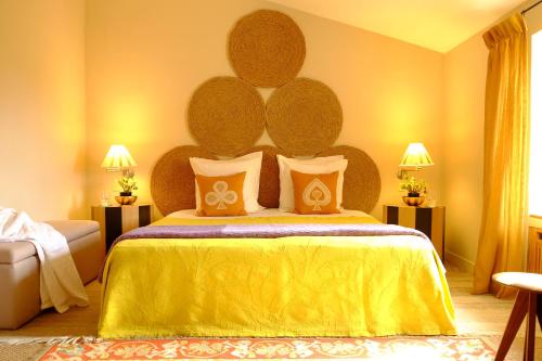 屈屈龙Le Pavillon de Galon的一间卧室配有一张带黄色床罩的大床
