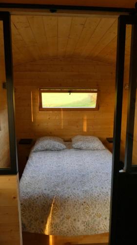 勒瓦德约尔Rigoulotte的配有窗户的小木屋内的一张床位