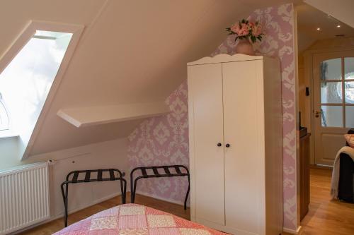 伊皮B&B De Drie Uiltjes的阁楼上一间卧室配有床和橱柜