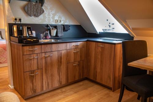 伊皮B&B De Drie Uiltjes的一个带木制橱柜和水槽的厨房