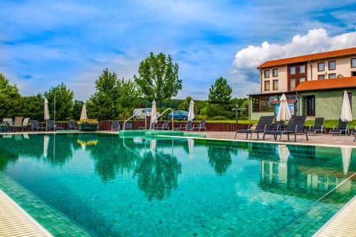 齐尔茨森林山酒店的一座带椅子的度假村的游泳池和一座建筑