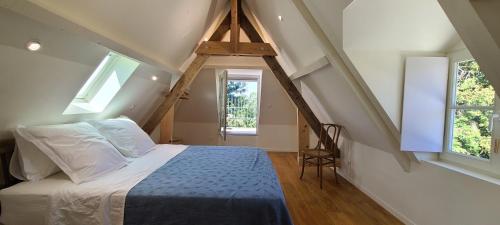 索米尔Le Bois Flotté - Maison au cœur de la Loire entre ville et nature的一间卧室设有一张床和两个窗户。