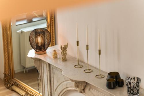 列日Appartement Guillemins station的客房设有带蜡烛和镜子的壁炉。