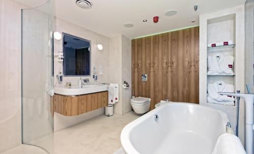 布拉格SKY SUITE HOTEL的带浴缸、盥洗盆和卫生间的浴室