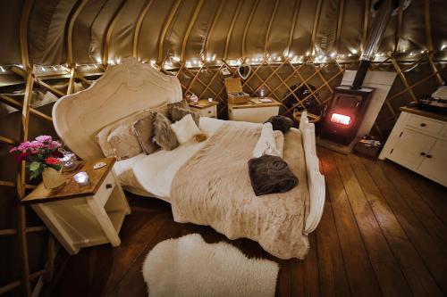 CauldonSecret Cloud House Holidays Luxury Yurts with Hot Tubs的蒙古包内一间卧室,配有一张大床