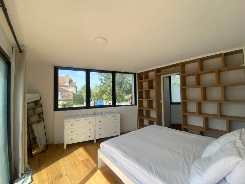 塔朗斯La Résidence Amal的一间卧室设有一张床和两个窗户。