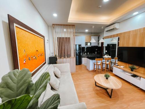雅加达2 Bedrooms Permata Hijau Suites Apartment的带沙发和桌子的客厅以及厨房。
