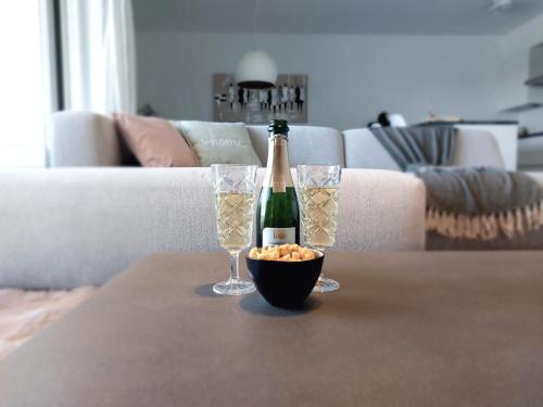 尼乌波特Duplex Villa Capricia appartement met zwembad Nieuwpoort Jachthaven的一瓶香槟和一张桌子上的两杯酒