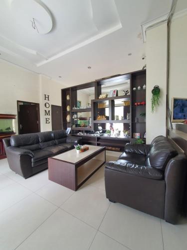 巴东Mahakam Guest House的客厅配有黑色真皮沙发和咖啡桌