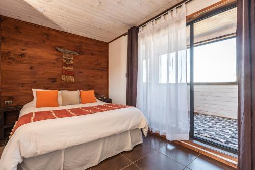 皮奇勒姆Pichilemu Apart Hotel的一间卧室设有一张床和一个大窗户