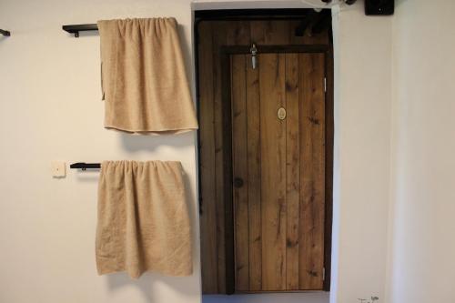 韦克舍73m2 Apartment with sauna in Växjö, Teleborg的浴室设有木门和2条毛巾。