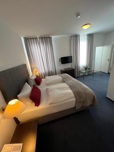 海德堡Hotel zum Ritter St. Georg的一间卧室配有一张带红色枕头的大床