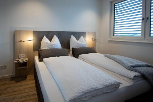 赫斯巴赫Livin63 Studio Apartments的一间卧室设有两张带白色床单的床和窗户。