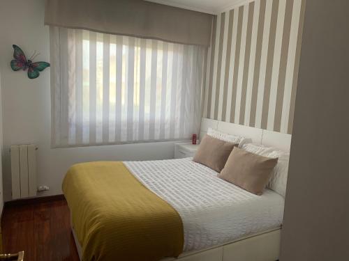 维戈Apartamento Conchita的卧室配有一张床铺,窗户上放着蝴蝶