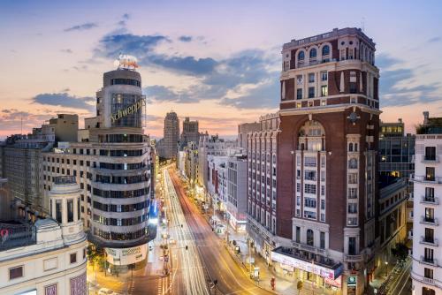 马德里马德里乌胡套房旅馆的黄昏时分有建筑物和交通的城市街道