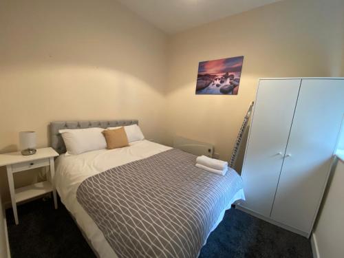 哈利法克斯Elmcroft Apartments Halifax City Centre的一间小卧室,配有床和床头柜