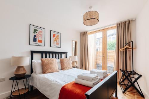 布里斯托Redland Stay In Bespoke Home 1 of 2的一间卧室配有一张带白色床单的床和一扇窗户。