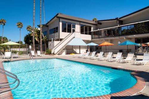 圣克莱门特圣克莱门特酒店的一座带椅子的游泳池以及一座建筑