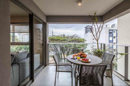 圣保罗Noon Vila Madalena的客房设有桌椅和大窗户。