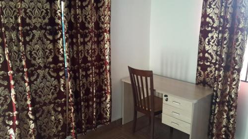 阿克拉Hayben serviced apartments的客房配有书桌、椅子和窗帘