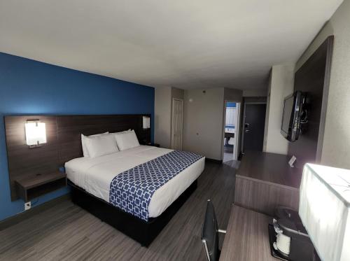 斯塔福德休斯顿斯塔福德舒格兰拉昆塔套房酒店的一间卧室设有一张大床和蓝色的墙壁