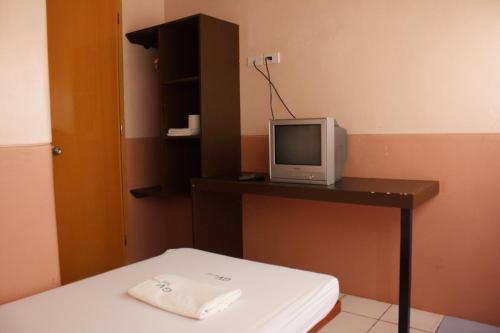 Sogod索戈GV酒店的客房设有书桌和桌子上的电视