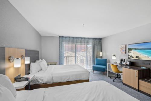 莫罗贝Hotel Avisa Downtown的酒店客房设有两张床、一张桌子和一台电视。
