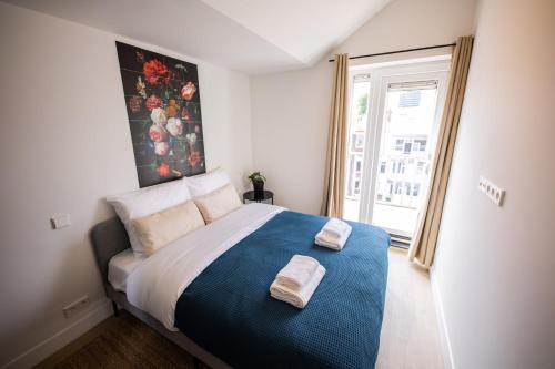 鹿特丹Happily 2 Bedroom Serviced Apartment 75m2 -NB306H-的一间卧室配有一张大床和两条毛巾
