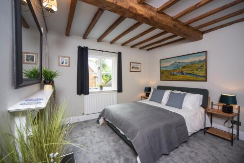 斯托尔河畔希普斯顿Cotswolds period townhouse near Stratford-upon-Avon, central location short walk to pubs, restaurants and shops的一间卧室设有一张床和一个窗口