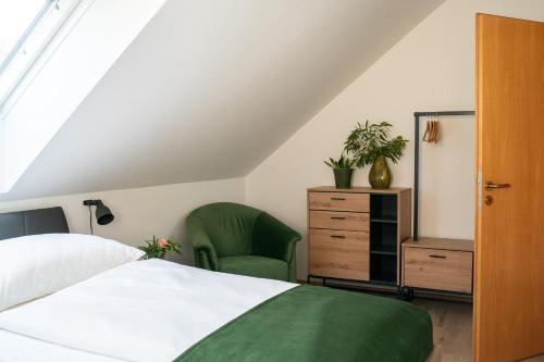 伊尔米茨Ferienhaus Kaiserbaum的卧室配有白色的床和绿色椅子