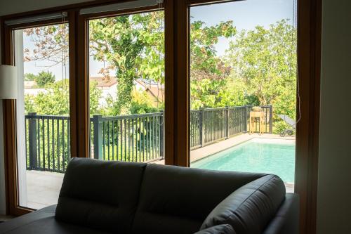 伊尔米茨Ferienhaus Kaiserbaum的带沙发的客厅,享有游泳池的景色