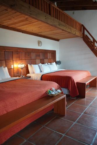 瓦斯卡坎波Torre del Conde的一间卧室设有两张带红色床单的床和楼梯。