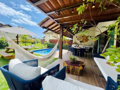 普拉亚多斯卡内罗斯Casa Luxo com piscina privativa próximo a Igrejinha - Com colaboradora e enxoval的一个带吊床的户外庭院和一个游泳池