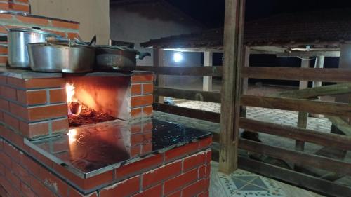 圣罗克迪米纳斯Pousada Canastra Mineira的砖炉,上面有锅碗瓢盆