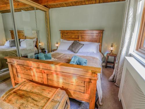 塔特舍尔Lakeside Lodge Retreat的一间卧室配有一张带木制床头板的大型木床