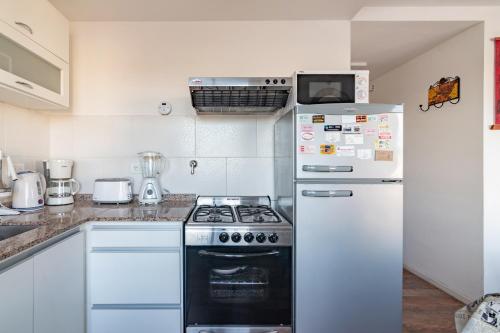 马德普拉塔Los Asturianos APART amentos 3的厨房配有炉灶和冰箱。