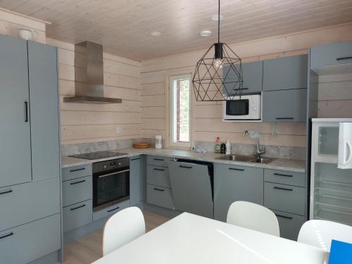 阿卡斯洛姆波罗Villa Ruskamaja的厨房配有灰色橱柜和白色家电