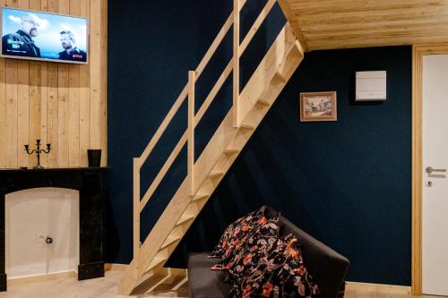 斯帕Le Studio Émeraude - Topdestination-Spa的一间带楼梯和电视的客厅