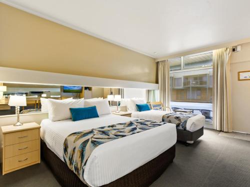 莱克斯恩特伦斯Comfort Inn & Suites Lakes Entrance的酒店客房设有两张床和窗户。