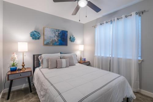 圣安东尼奥Eastlawn Place cozy 2 bdrm townhome near downtown San Antonio的卧室配有白色的床和吊扇
