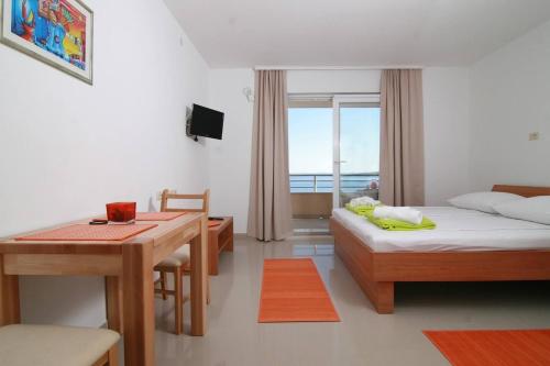 布雷拉Family friendly apartments with a swimming pool Brela, Makarska - 19998的酒店客房配有一张床铺、一张桌子和一张书桌。