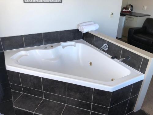 陶波绝对湖景汽车旅馆的浴室内设有大型白色浴缸。