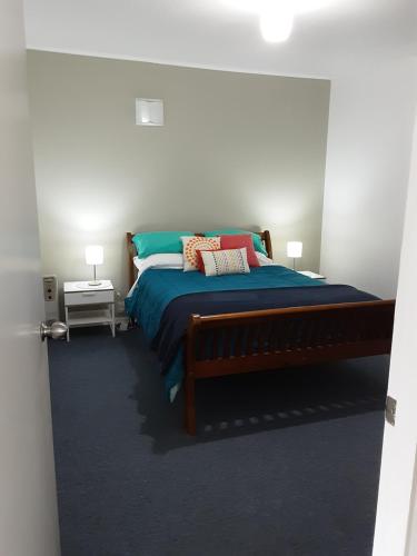 FeatherstonRelax@99的一间卧室配有一张带蓝色床单和枕头的床。